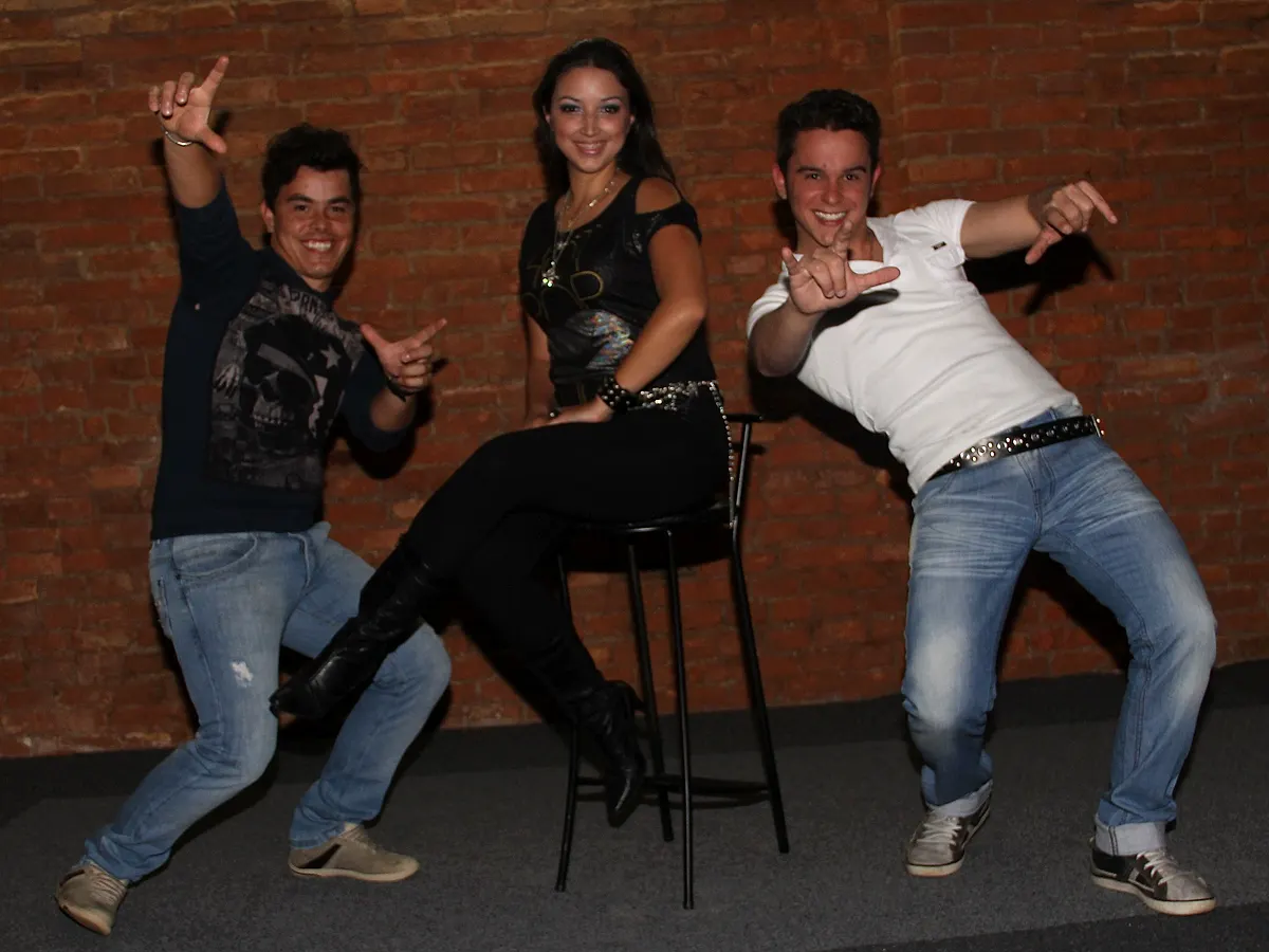 Três integrantes em pose de dança pop